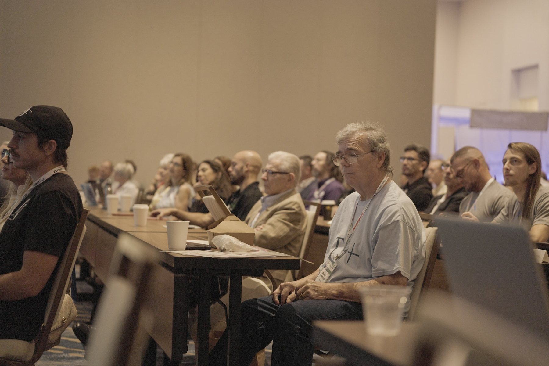 The audience seated at tables during a conference session