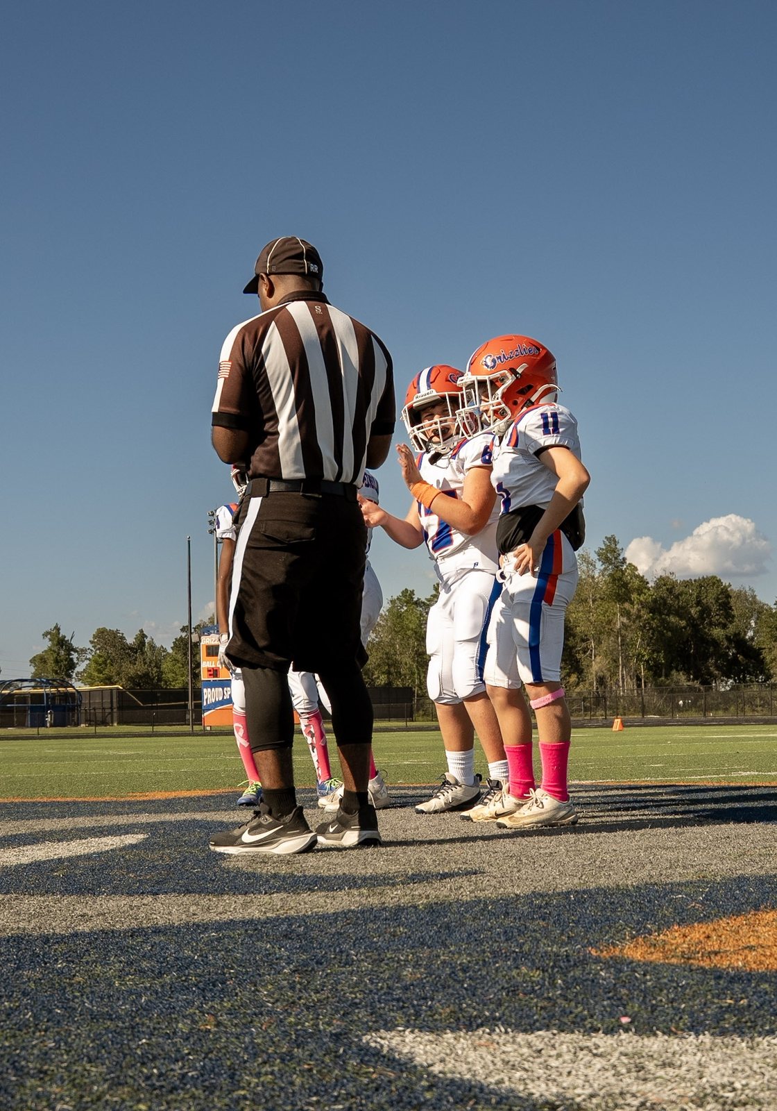 A referee with youth football captains at midfield