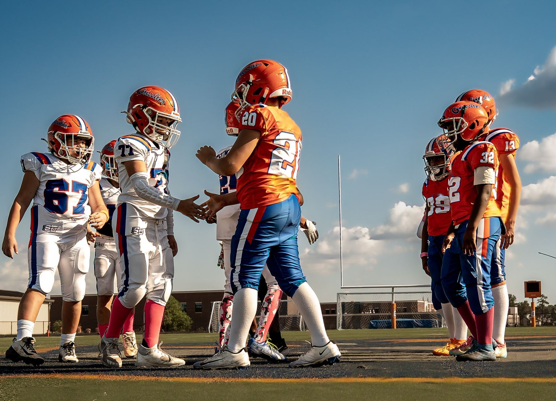 Youth football players shaking hands at midfield