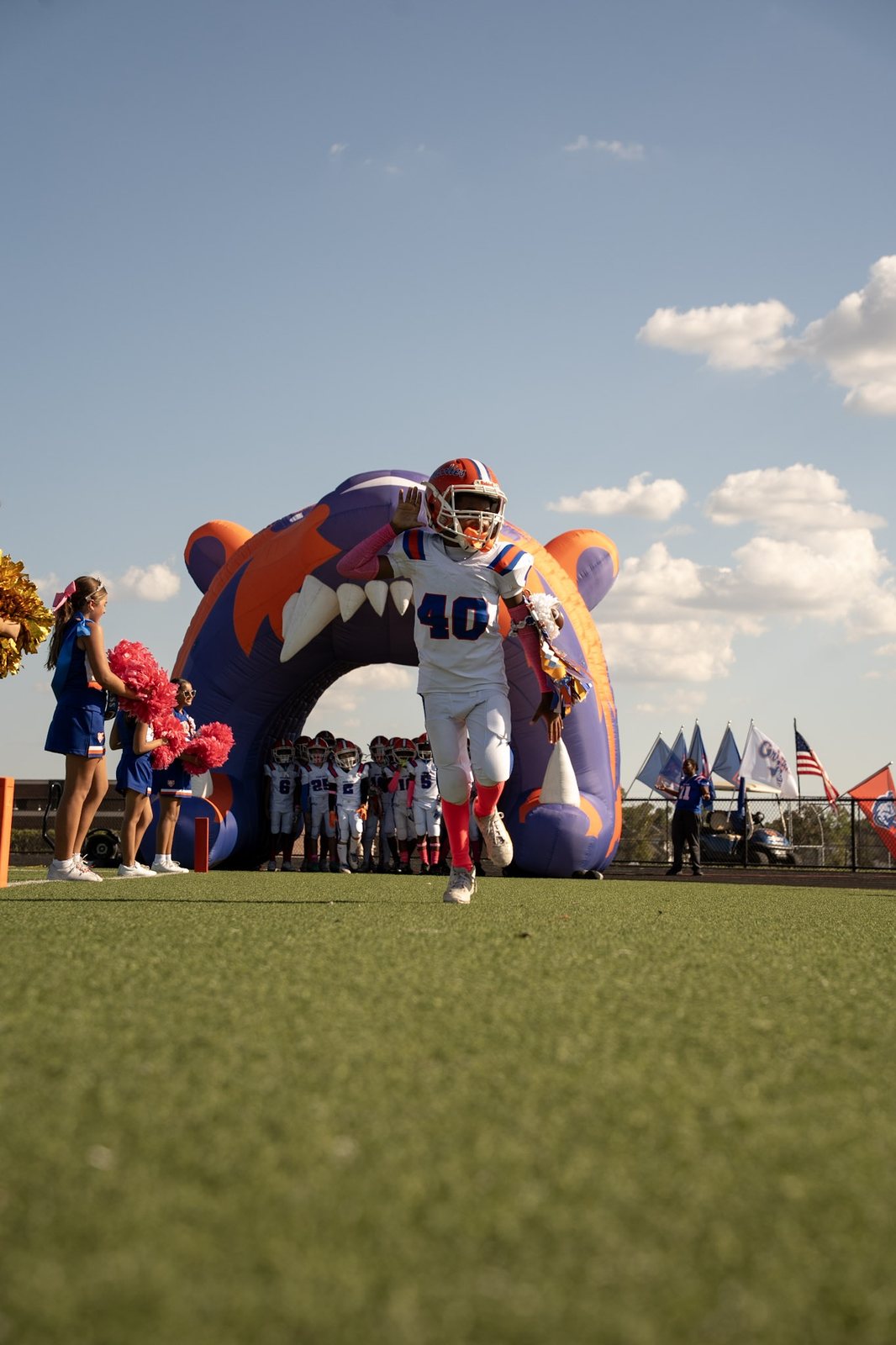A youth football player running out through an inflatable tunnel