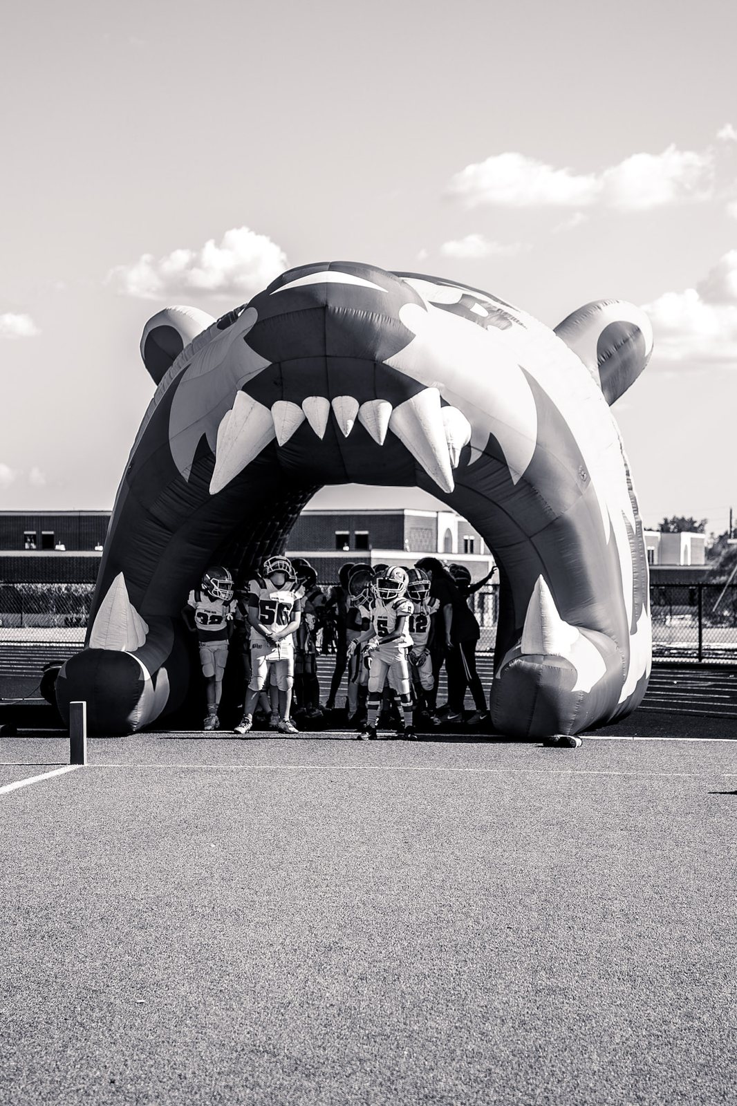Black-and-white photo of an inflatable team tunnel with players gathered inside