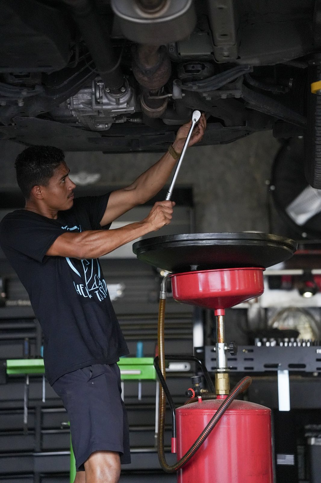 A mechanic working under a car on a lift
