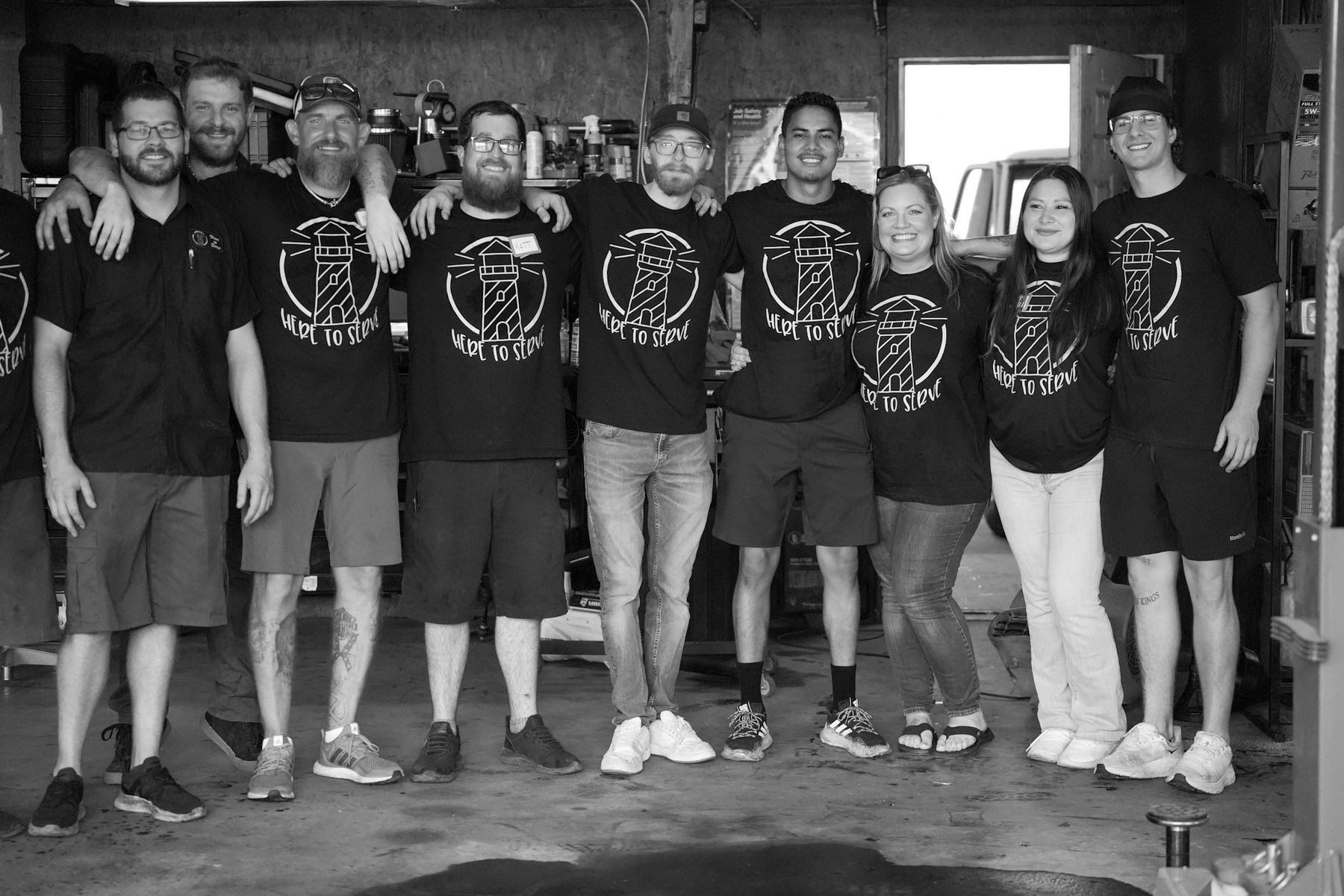Black-and-white photo of the shop team standing together