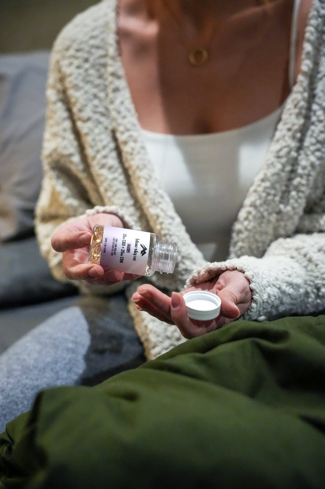 Capsules being poured into an open palm, a product bottle in hand