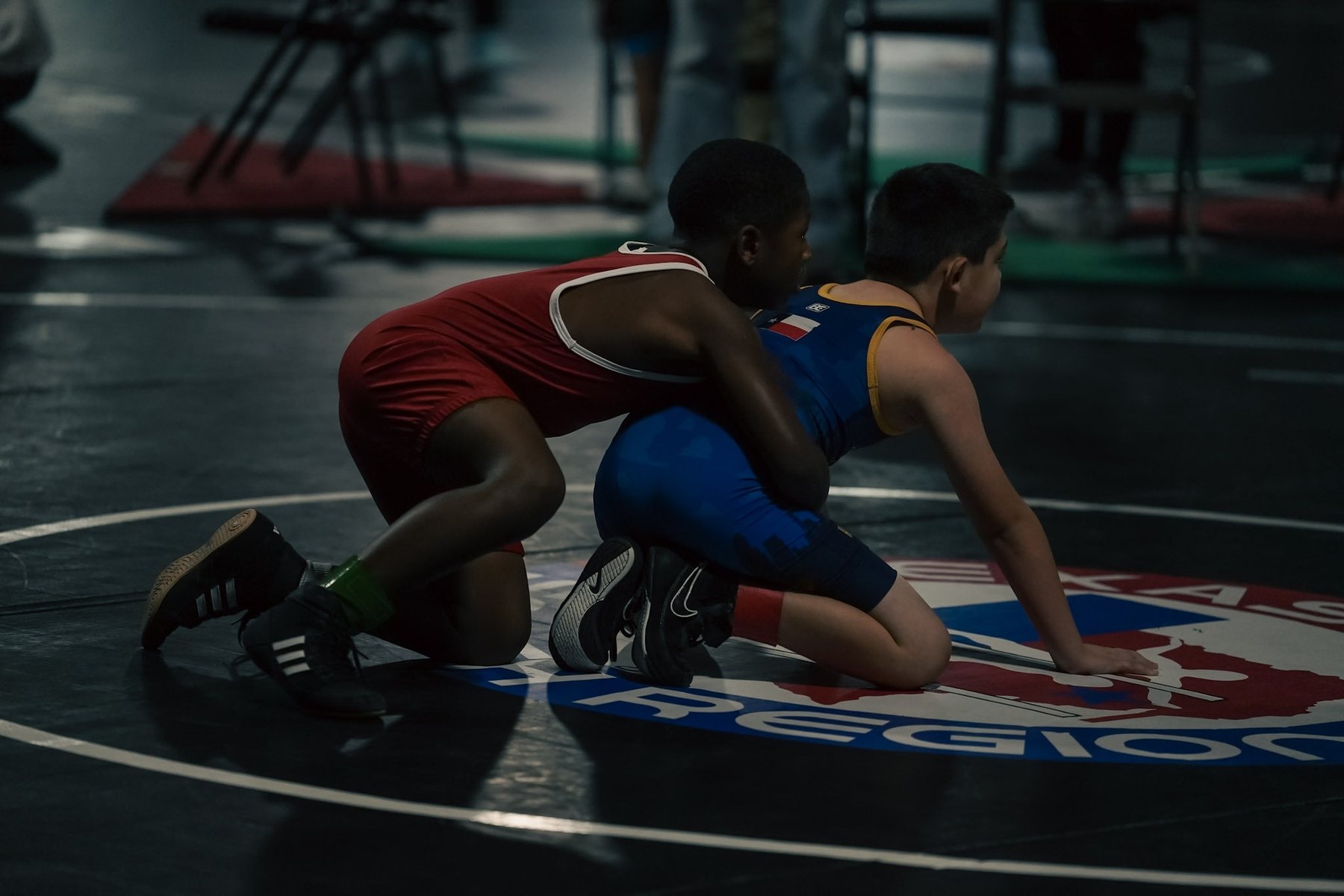 Two youth wrestlers in the referee&rsquo;s position on the mat
